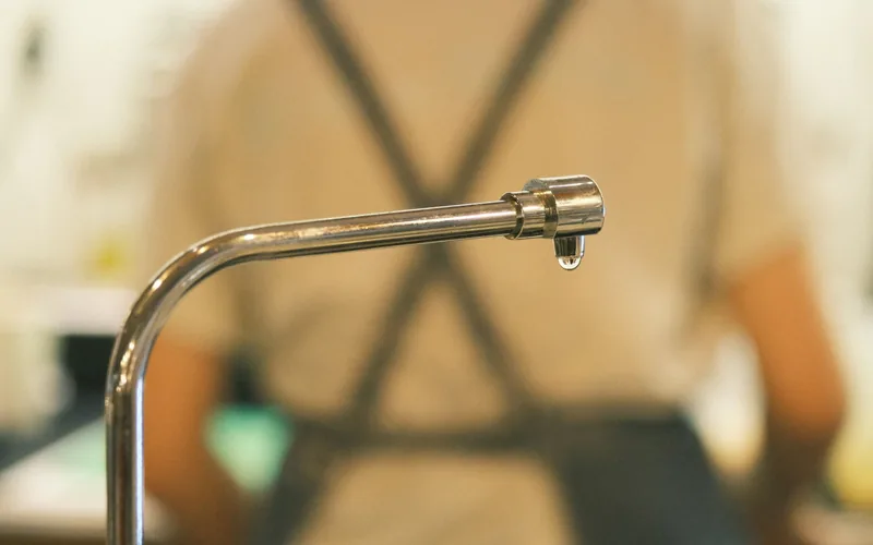 Faucet dripping water, an early sign of a hidden household leak