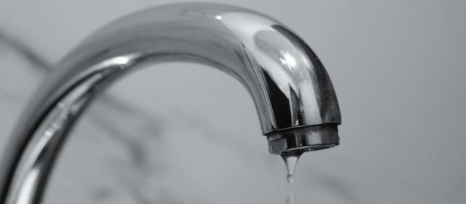 Water dripping from a faucet, a leak that needs same-day repair