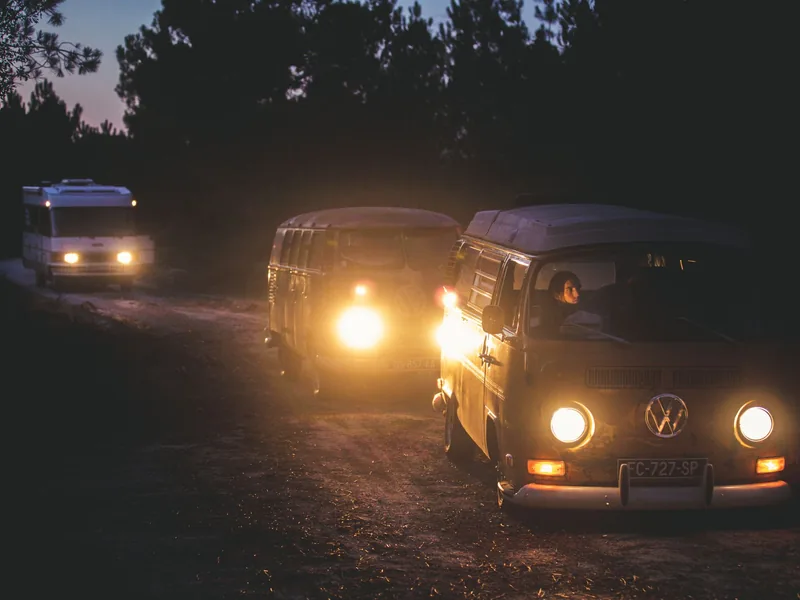 Service vans with headlights on heading out on a night emergency call