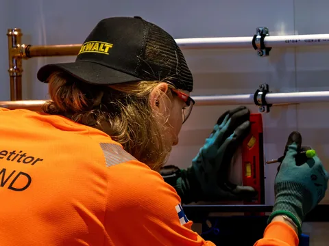 Plumber adjusting copper water pipes during a leak repair