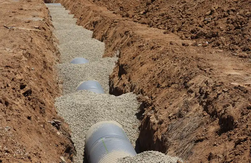 Open trench with buried pipe exposed for underground leak repair