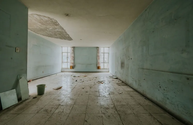 Room with water-stained walls and damaged ceiling from a hidden leak
