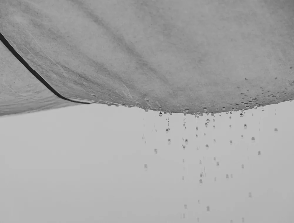 Water dripping from a stained ceiling after a hidden pipe leak